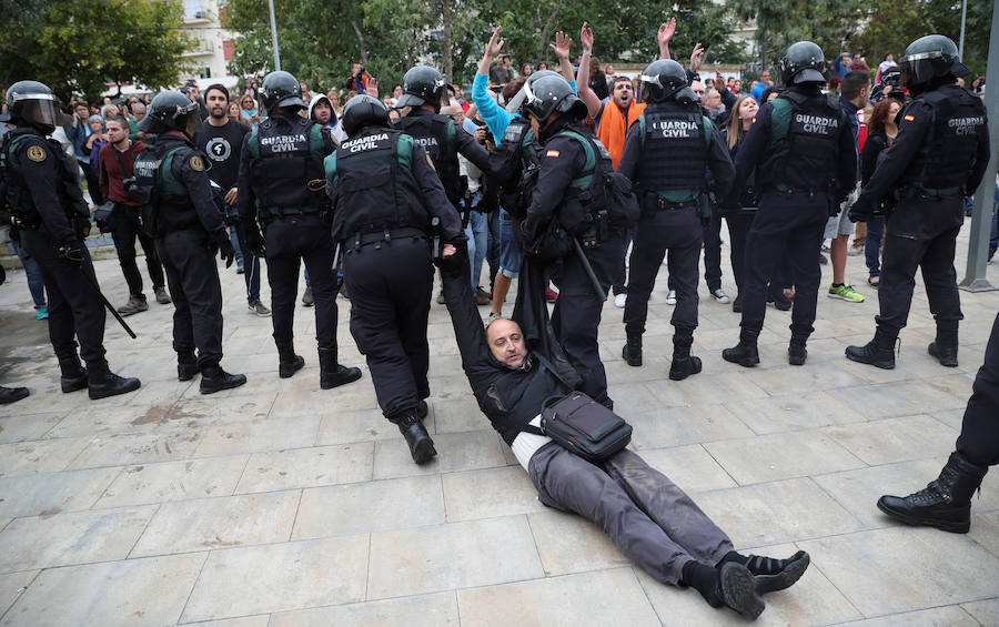 Agentes de la Guardia Civil desalojan a un manifestante de un colegio electoral.