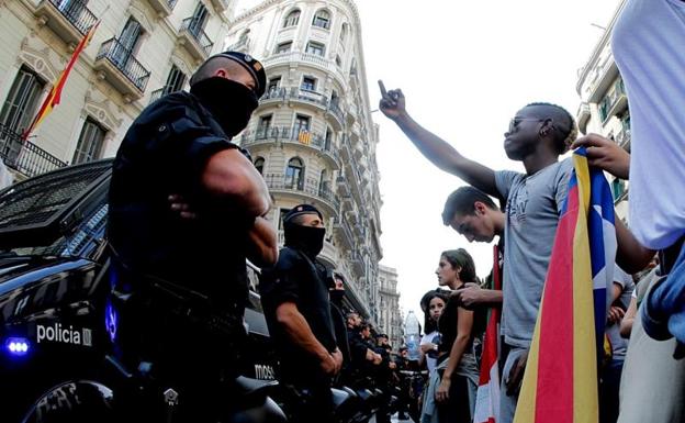 Manifestantes ifrente a la Policía en Barcelona durante la protesta por la intervención policial y las cargas en el referéndum