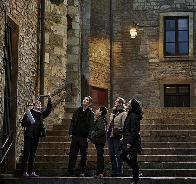 La guía explica detalles de la ruta en las escaleras que conducen a la plaza del Machete. 