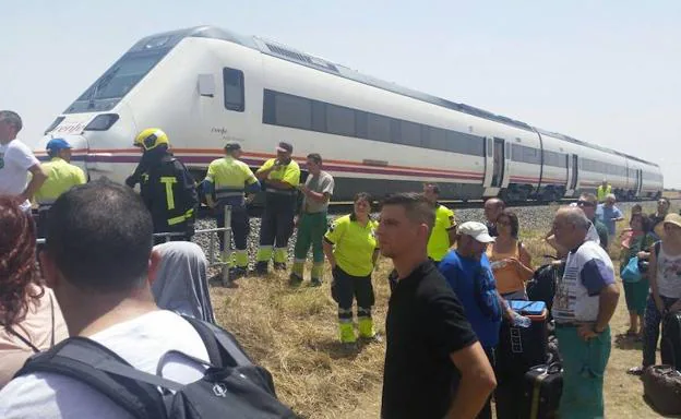 Imagen principal - Arriba, pasajeros tirados tras arder un vagón del tren Madrid-Badajoz el pasado 13 de julio. Los trenes no son AVE ni Talgo ni Alvia, solo diésel regionales. Como los modelos R-598 que descansan en la Estación de Cáceres (abajo), los más habituales en las vías extremeñas.