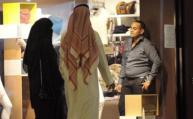 Una mujer, acompañada por un hombre en un centro comercial de Arabia Saudí. 
