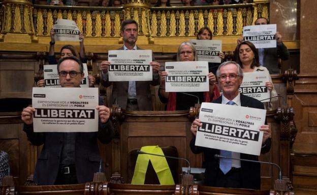 Carteles y un lazo amarillo en el pleno. 