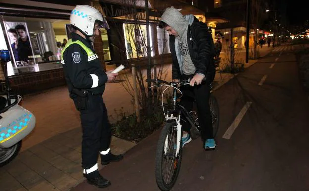 Un agente de la Policía Local impone una sanción en Vitoria a un ciclista que circula sin luces. 