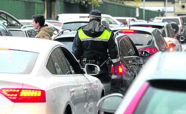 Un agente de la Policía Local vigila las dobles filas frente al colegio Marianistas.