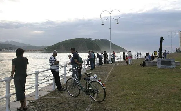 Vecinos observan el Cantábrico desde el Paseo de la Grúa en Ribadesella.