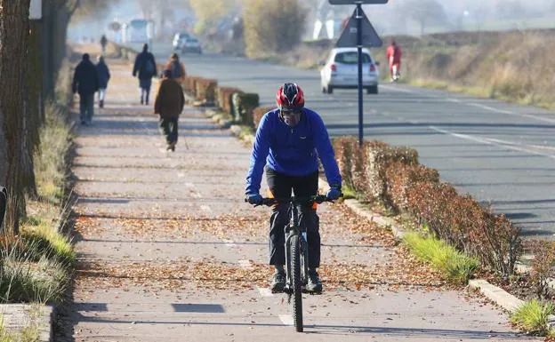 Un ciclista circula bien pertrechado contra el frío, en una imagen tomada ayer en Vitoria. 