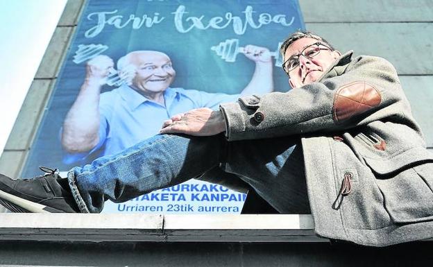 El médico pamplonés posa en el centro de salud de Lakuabizkarra, frente a un cartel de la campaña de la gripe. 