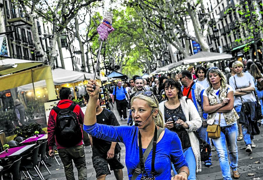 Una guía señala el camino a un grupo de turistas en la siempre masificada Rambla de Barcelona.