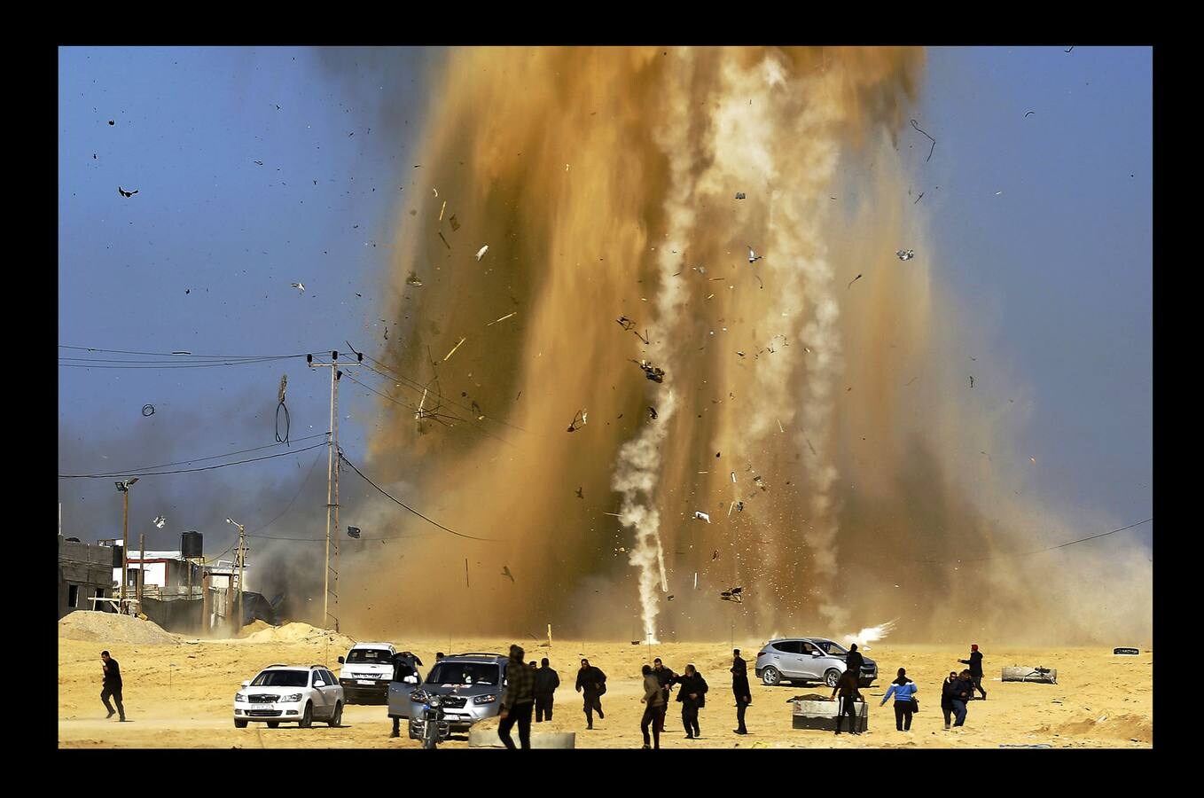 Febrero 2017. Palestinos corren a cubrirse del humo después de un ataque aéreo israelí.