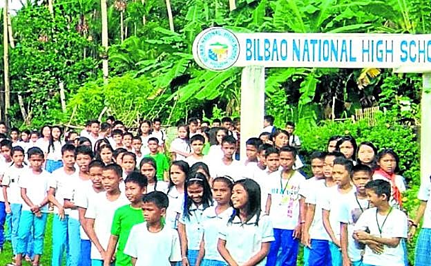 Imagen principal - La escuela de secundaria de Bilbao y las colinas situadas en la boca de la bahía de Calanaga, donde se encuentra la población.