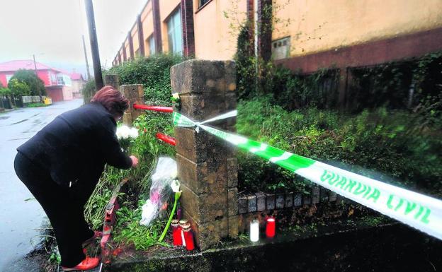 Una mujer deposita unas flores en homenaje a Diana Quer ante el pabellón donde permaneció escondido el cuerpo de la joven desde su asesinato. 