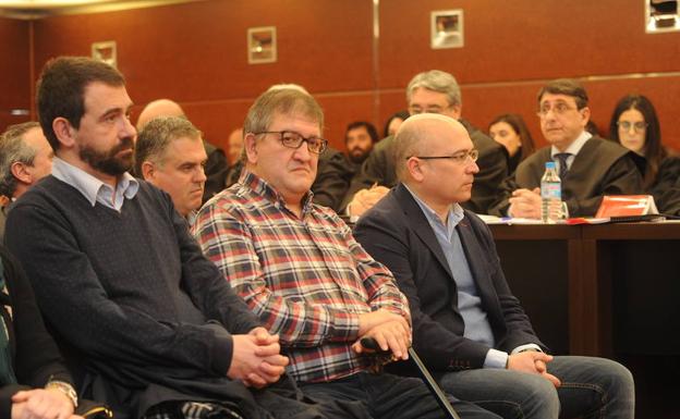 Imagen principal - Koldo Ochandiano, Aitor Telleria y Alfredo de Miguel, en el banquillo de los acusados. Abajo, el tribunal que juzgará el caso. Periodistas siguen el juicio desde una sala de prensa.