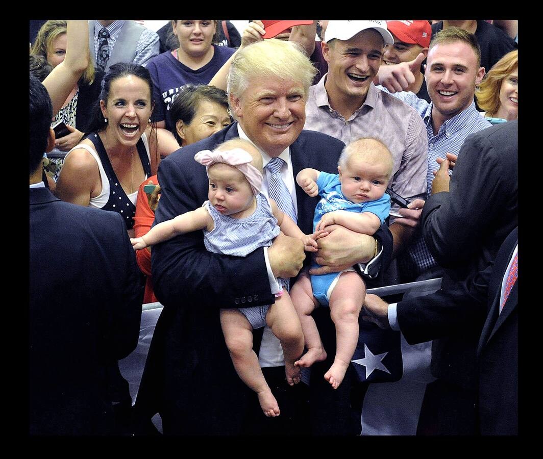El presidente Donald Trump sujeta a dos bebes en Colorado.