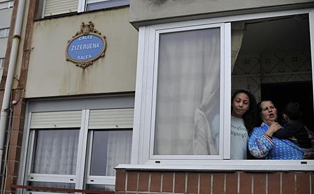 Imagen principal - Carmen Jiménez, con su familia, asomada a la ventana por donde intentaron robarle. El pescadero Sergio López analiza la situación en su puesto del mercado. Julián Jiménez explica lo ocurrido el miércoles en su sede.