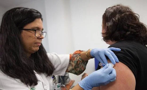 Una mujer se vacuna contra la gripe en un centro de salud. 