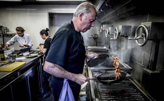 Víctor Arguinzoniz, salteando con cariño, en sus parrillas en el asador 'Etxebarri'.