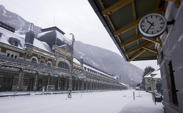 Un reloj preside el apeadero, que recibe y despide cuatro trenes diarios en la actualidad. Enfrente, el imponente edificio que albergará el hotel de cinco estrellas. 