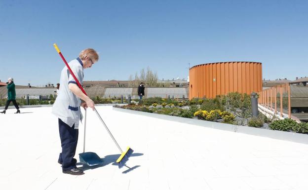 Una limpiadora barre el suelo de la terraza del Palacio de Congresos Europa de Vitoria. 