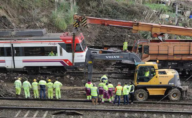 Un tren-grúa intenta izar el convoy siniestrado para que los trabajadores y una excavadora retiren el escombro, ayer a la mañana en el túnel de Urbinaga. 