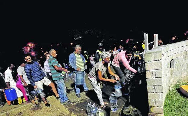 Vecinos de Ciudad del Cabo hacen cola junto a las fuentes de agua potable en busca de suministro.