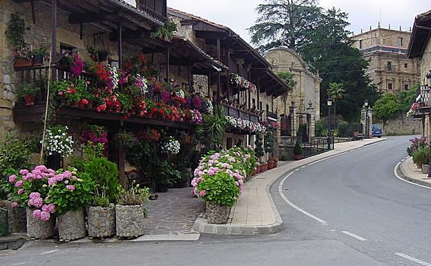 Barrio de Postigo, en Villacarriedo. Al fondo, el Palacio de Soñanes. Debajo, un fotógrafo busca un encuadre para un puente en el valle.
