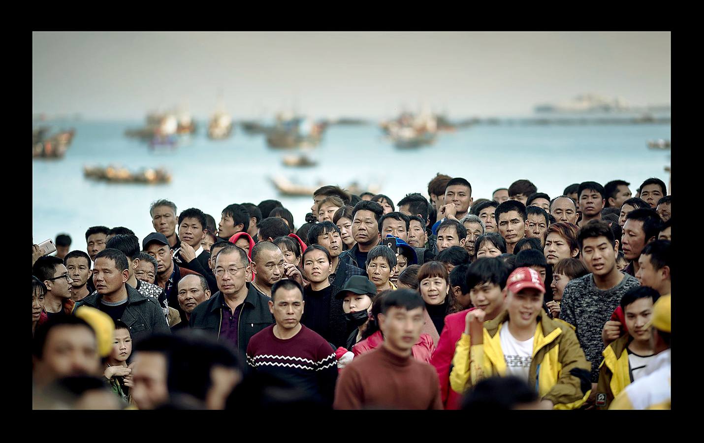 «El tablero de los dioses oceánicos» es uno de los más sorprendentes festivales que se celebran en Fuye, una localidad de la isla de Nanri, en la provincia china de Fujian. Vestidos con prendas bordadas y coronadas sus cabezas con intrincadas coberturas, una veintena de participantes cantan y blanden espadas y estandartes mientras son transportados hacia el mar en palanquines portados por convecinos. La pesca sigue siendo un trabajo arriesgado para los moradores de Fuye, que se hacen a la mar en pequeñas embarcaciones acompañados por imágenes y estatuillas para que los dioses les protejan. «Podemos pedirles que nos mantengan a salvo en el mar, pero no pueden darnos peces ni decirnos dónde hay más,» dijo Zhou, uno de tantos pescadores que estudia inglés con la esperanza de obtener trabajo en un barco de altura.