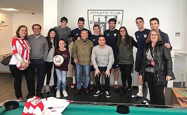 Marcos Torres y su familia posan en Lezama junto a los jugadores del Athletic.