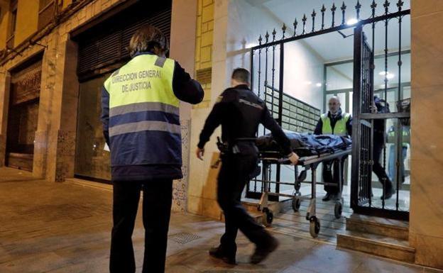 Miembros del retén fúnebre y agentes del Cuerpo Nacional de Policía retiran los restos humanos hallados en el interior de una vivienda de Benimaclet.