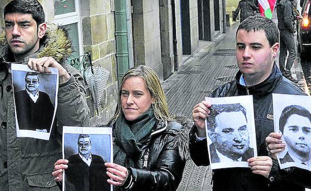 Varios dirigentes del PP vasco, entre ellos su secretaria general, Amaya Fernández, muestran fotografías de los nueve asesinados por ETA en Durango.