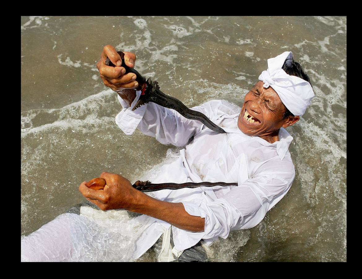 Durante el Nyepi o 'Día del Silencio', los habitantes de la isla indonesia de Bali no deben trabajar, comer, encender la luz ni realizar actividades que les procuren placer. Bali es la única isla que profesa mayoritariamente la religión hindú en Indonesia, un país en el que alrededor del 85 por ciento de los 240 millones de habitantes practican el islam. La celebración que los hinduistas llevan a cabo en esta isla durante el 'Nyepi' se traslada también a los turistas, a quienes se pide que permanezcan en sus hoteles y no acudan a las playas, restaurantes o comercios durante la jornada. Las fotografías muestran la celebración del Melasti, un ritual de purificación que se celebra en Bali, pocos días antes del Nyepi.