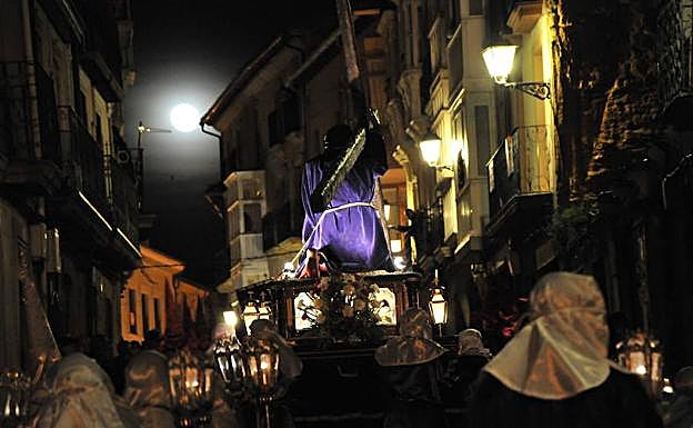 El paso que representa la primera caída de Cristo en el camino hacia el Calvario recorre las calles de Haro, con la luna llena en segundo plano.