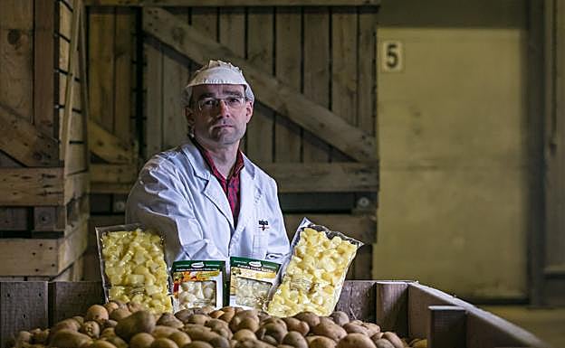 Koldo López de Robles posa entre patatas y envases del producto.