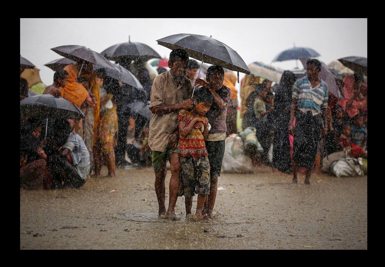 Refugiados rohinyás intentan resguardarse de las lluvias torrenciales mientras están retenidos por la Guardia Fronteriza de Bangladesh (BGB), después de cruzar ilegalmente la frontera, en Teknaf (Bangladés), el 31 de agosto de 2017.