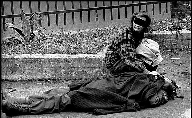 Una mujer atiende a un policía herido en Eibar.