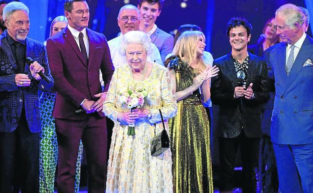 La soberana británica sonríe a la audiencia en presencia del príncipe Carlos, Kylie Minogue, Jamie Cullum y Tom Jones. Abajo, aspecto del Albert Hall.