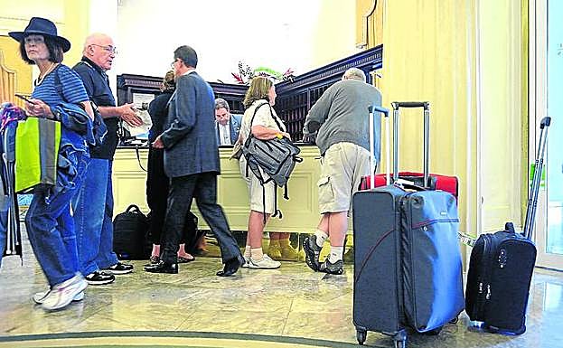 Viajeros llegan a la recepción del hotel Carlton.