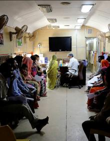 Imagen secundaria 2 - Cuatro pacientes se cubren un ojo con una gasa después de ser intervenidas de cataratas en el tren hospital.. A continuación, imagen del Lifeline Express, que empezó a rodar en julio de 1991. En su primer viaje llevaba tres vagones. Ahora tiene siete después de que, en diciembre de 2016, recibiera un nuevo obsequio de Indian Railways. Finalmente, los enfermos aguardan a ser atendidos en la sala de espera.