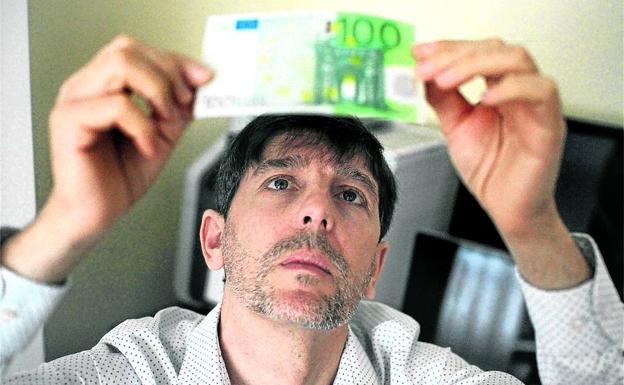 José Luis Mintegia analiza un billete de 100 euros para determinar si es una falsificación.