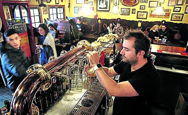 Imagen principal - Molly Malone. El bar de Estraunza presume de nueve cervezas de cañero y otras 56 en botellín. Abajo a la izquierda, Obalisko. Marisol Rivero (sentada), posa junta a aficionados del Universitario en su bar de Rekalde. Abajo a la derecha, residence. Manu Iturregui regenta uno de los bares 'rugbiers' más icónicos de Bilbao. 