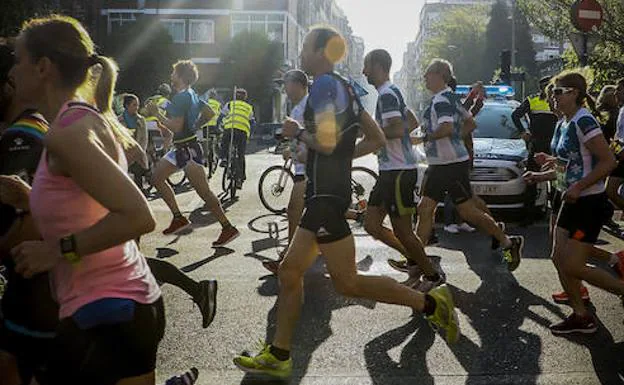 Voluntarios y policía en un cruce de Vitoria durante la disputa del Maratón Martín Fiz. 