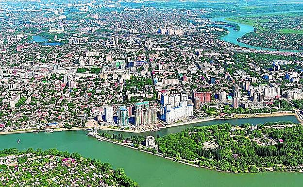 Imagen principal - 1. El río Kubán atraviesa la ciudad de punta a punta. 2. La monumental plaza Zhukov. 3. Una mujer y un niño, sentados en la escultura dedicada a los cosacos.