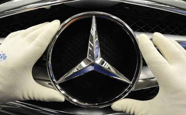 Un trabajador coloca la estrella en uno de los modelos de Mercedes.