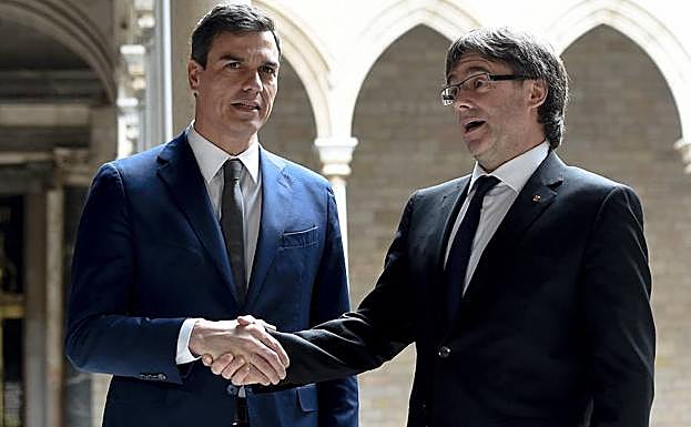 Pedro Sánchez (i) estrecha la mano de Puigdemont. 