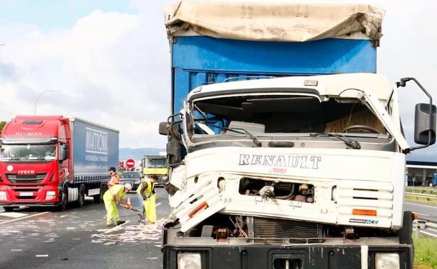 Varios operarios limpian la calzada de la A1 donde se ha registrado el accidente.