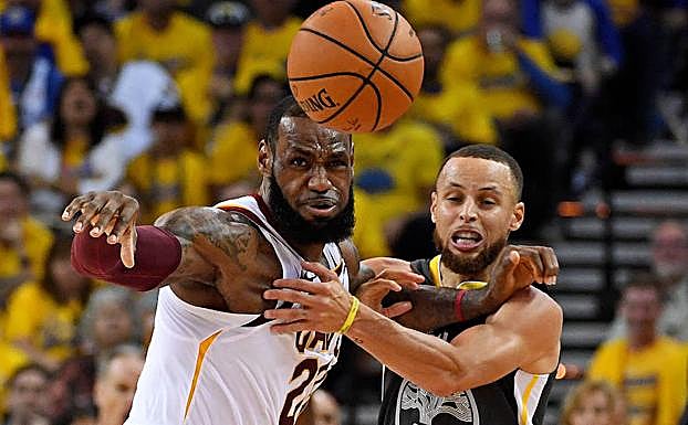 James (i) y Curry pugnan por el balón. 