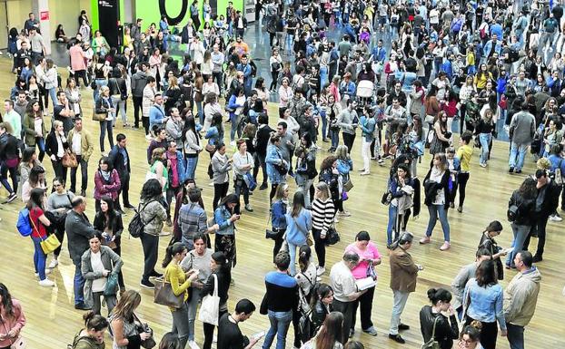 Los opositores comprueban en un panel el pabellón que les corresponde para examinarse.