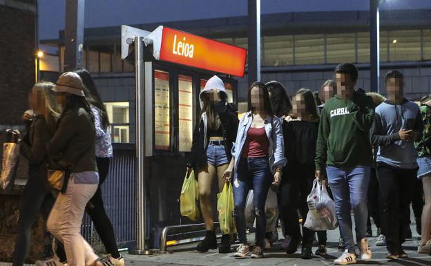 Varios jóvenes salen del metro en Leioa con bolsas llenas de botellas durante las fiestas de 2017. 