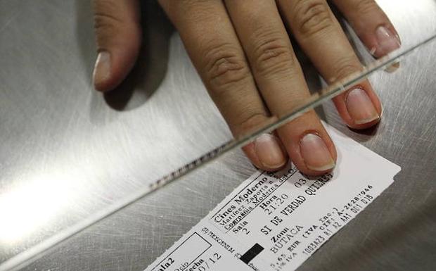 Una mujer entrega una entrada de cine.