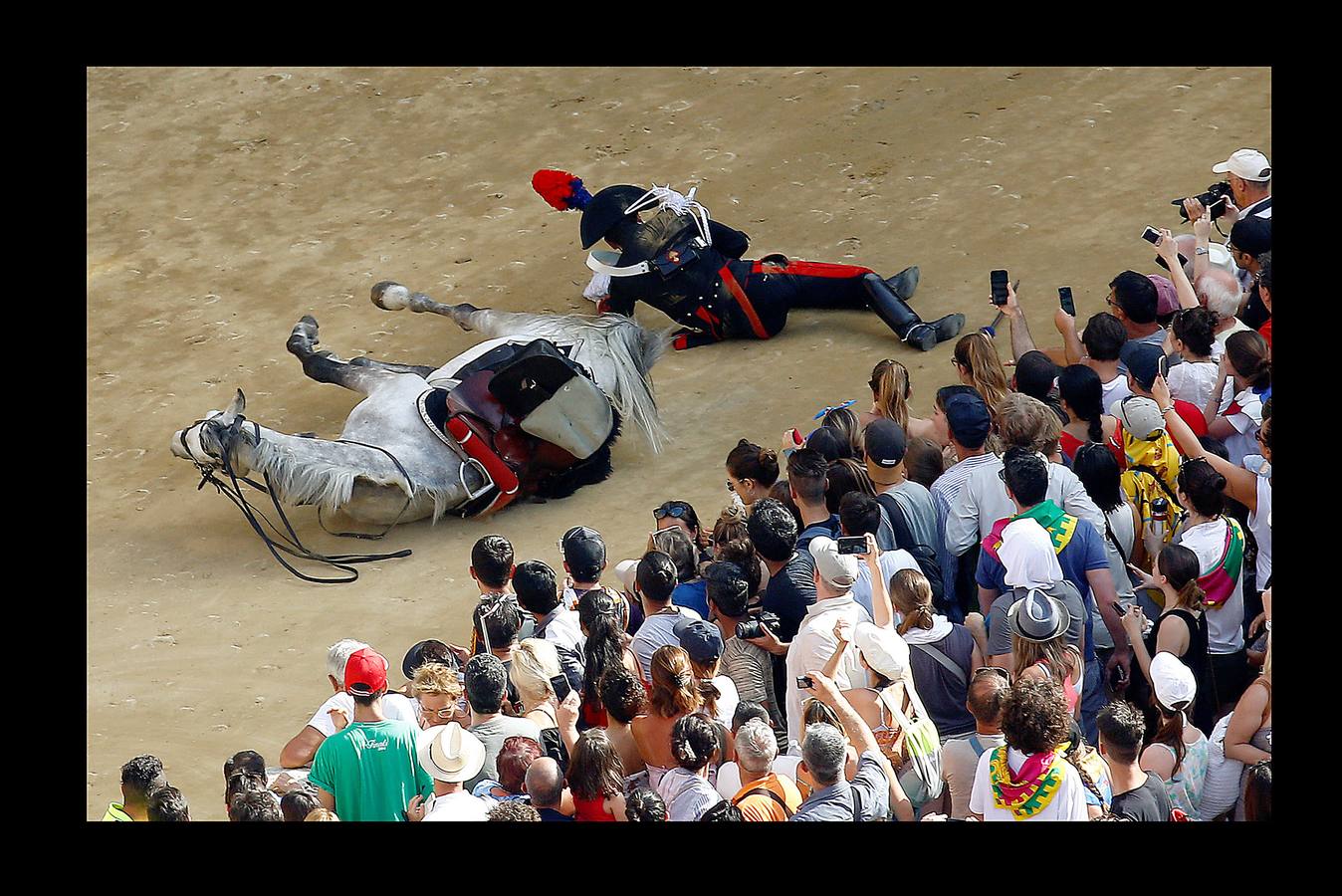 En la Piazza del Campo, en pleno corazón de Siena, en la Toscana, se celebra cada año, en dos ocasiones (las fotografías se tomaron el 2 de julio), la carrera de caballos de origen medieval conocida como «Il Palio.» La ciudad se engalana con estandartes, blasones y guirnaldas para celebrar tres días de alegría durante los cuales, además de participar en las bendiciones de los animales, es posible disfrutar de música y conciertos. En la carrera participan diez caballos, que representan a alguna de las «contradas» o distritos de la ciudad, y han de dar tres vueltas completas a la Piazza del Campo. El primero en terminarlas, con o sin jinete, será el ganador.