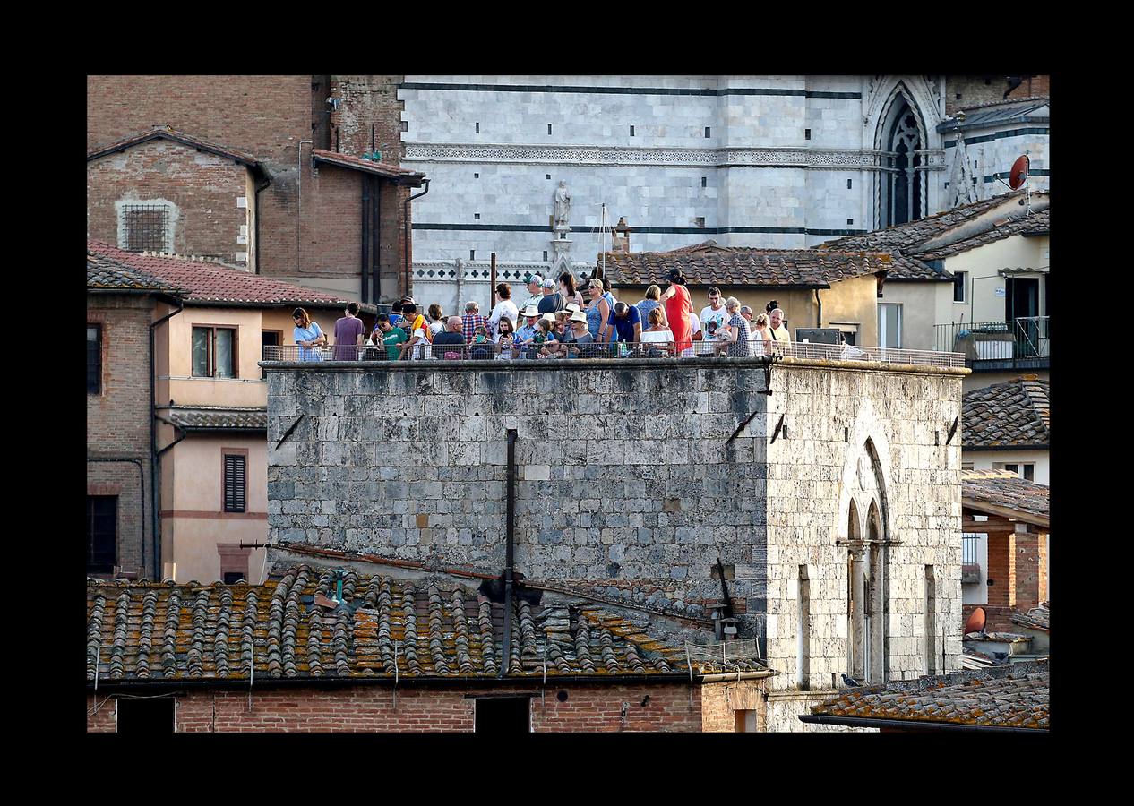 En la Piazza del Campo, en pleno corazón de Siena, en la Toscana, se celebra cada año, en dos ocasiones (las fotografías se tomaron el 2 de julio), la carrera de caballos de origen medieval conocida como «Il Palio.» La ciudad se engalana con estandartes, blasones y guirnaldas para celebrar tres días de alegría durante los cuales, además de participar en las bendiciones de los animales, es posible disfrutar de música y conciertos. En la carrera participan diez caballos, que representan a alguna de las «contradas» o distritos de la ciudad, y han de dar tres vueltas completas a la Piazza del Campo. El primero en terminarlas, con o sin jinete, será el ganador.